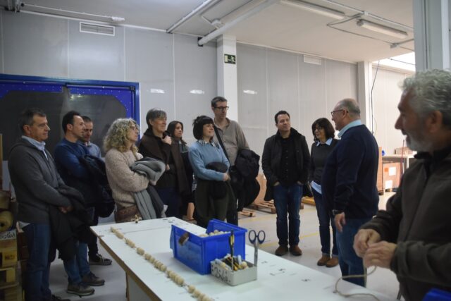 Imagen. La delegación del Centro de UNED Barbastro atienden las explicaciones de José María Calasanz en el taller de manipulados de Somontano Social.