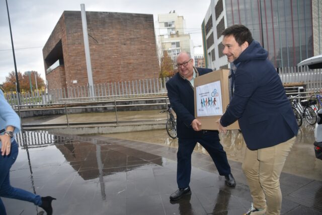Imagen. José María Calasanz, gerente de Somontano Social, y Jesús Alijarde, de la empresa Ibersyd, traslada la caja que contiene los calendarios solidarios de Somontano Social y CARTV.