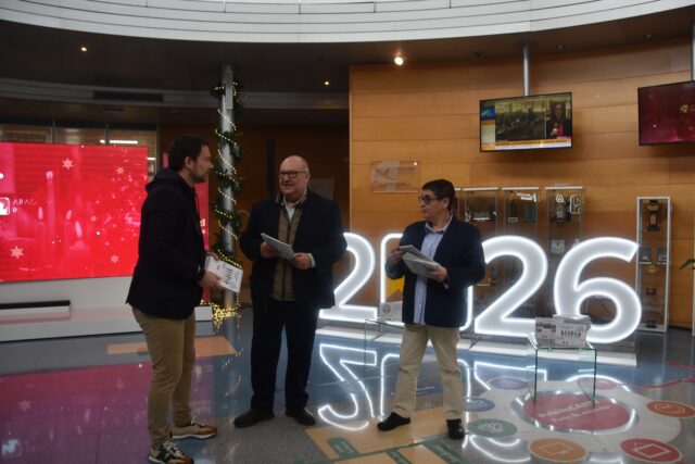 Imagen. Jesús Alijarde, de Ibersyd; José María Calasanz, gerente de Somontano Social; e Isabel Calderón, responsable de Impresión y ensobrado de Somontano Social, con los calendarios en las instalaciones de CARTV.