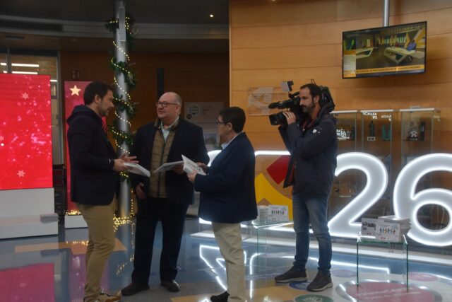 Imagen. Un cámara de televisión graba a José María Calasanz, gerente de Somontano Social, conversando con Jesús Alijarde, de Ibersyd y con Isabel Calderón, responsable de Impresión y ensobrado de Somontano Social, en las instalaciones de CARTV.
