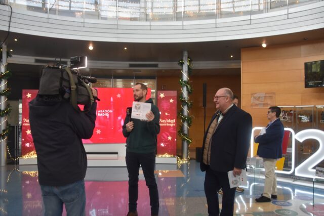 Imagen. Un periodista de CARTV presenta a José María Calasanz, gerente de Somontano Social, antes de hacerle una entrevista sobre el calendario solidario en las instalaciones de CARTV.