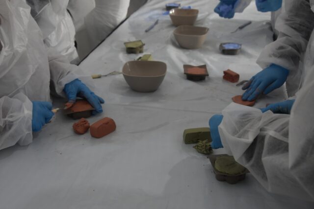 Imagen. Vista de las manos de varios escolares trabajando la arcilla en un molde en el taller de modelado de Molithe, marca propia de Somontano Social CEE.