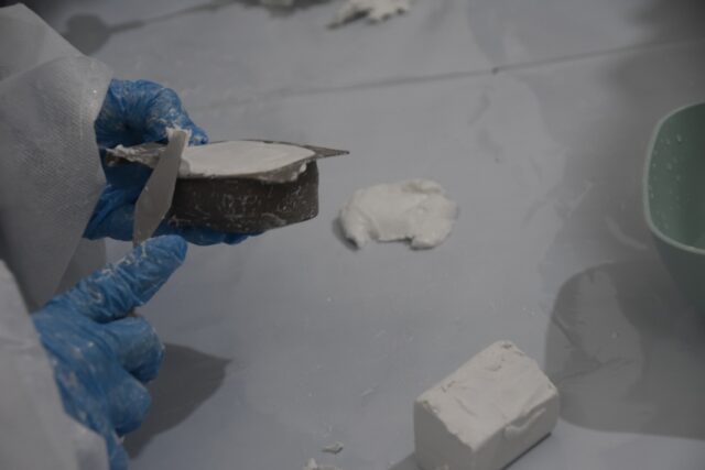 Imagen. Primer plano de las manos de un escolar trabajando la arcilla en un molde en el taller de modelado de Molithe, marca propia de Somontano Social CEE.