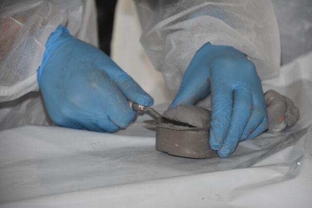 Imagen. Primer plano de las manos de un escolar trabajando la arcilla en un molde en el taller de modelado de Molithe, marca propia de Somontano Social CEE.