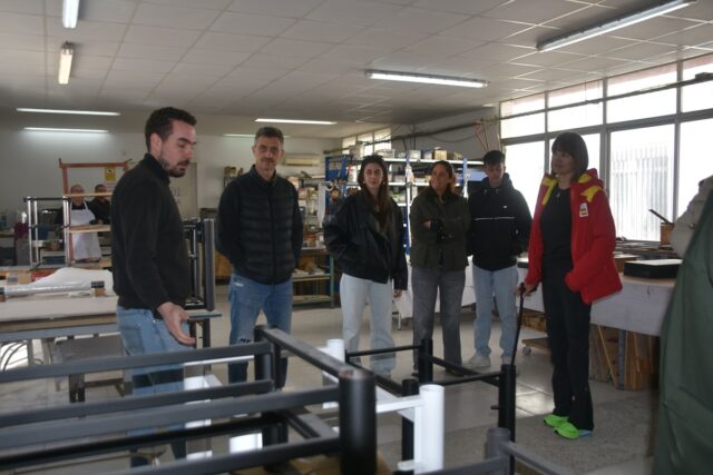 Imagen. Eric García, a la izquierda de la imagen, explica detalles de la fabricación de los racks de sonido en el taller de Artesanía Audio a Irene Villa y sus acompañantes.