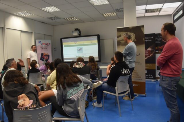 Imagen. Foto de grupo, tomada de espaldas, del grupo de alumnos de los CRAs Vero-Alcanadre y A Redolada durante el taller interactivo de Impresión 3D e IA, en la sede de Somontano Social, el Centro Especial de Empleo de la Fundación AltoAragón Integración (FAI), impulsor del proyecto 'Con-Ciencia' junto al CRIE de Benabarre.