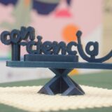 Imagen. Fotografía del logotipo del proyecto Con-Ciencia realizado con filamento azul en la impresora 3D en las instalaciones de Somontano Social, el Centro Especial de Empleo de la Fundación AltoAragón Integración (FAI).