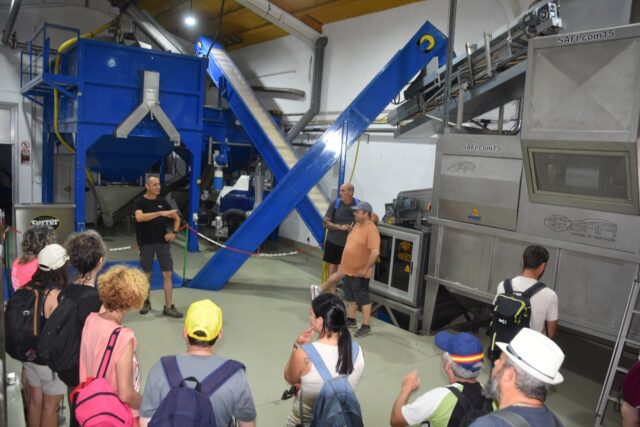 Imagen. Sergio Ferrer, de Aceites Ferrer, recibe en su almazara a los trabajadores de Somontano Social que, en semicírculo, escuchan sus explicaciones. 